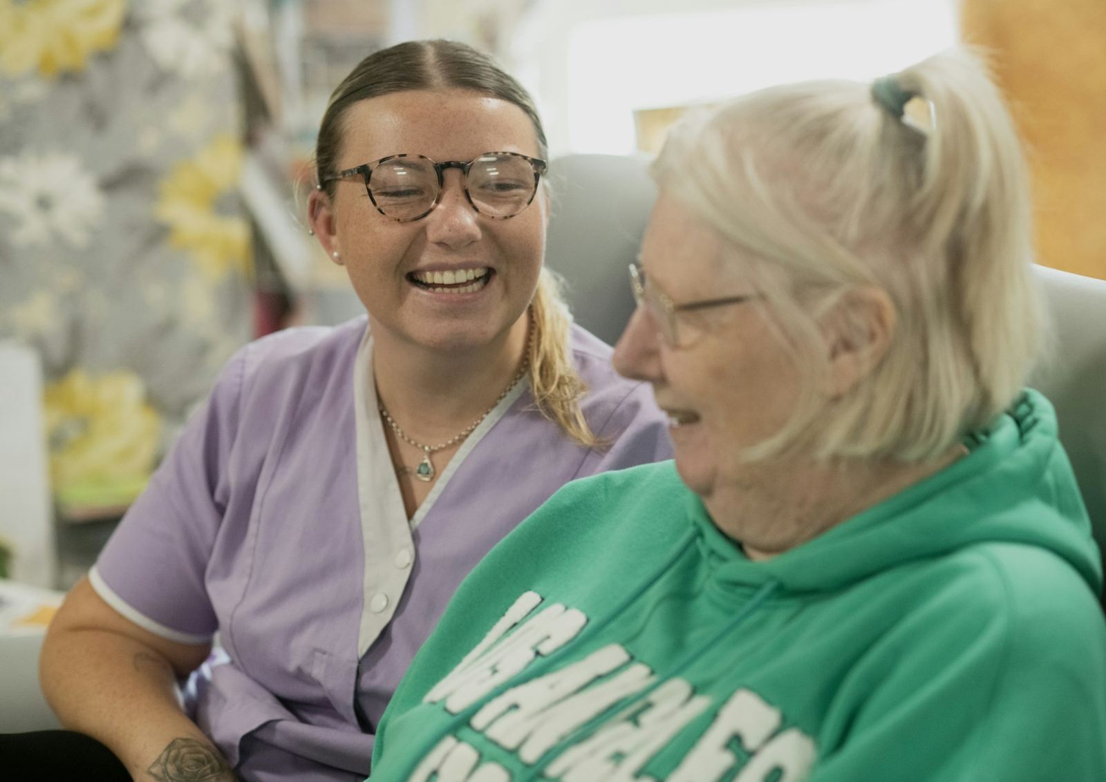 A caregiver and resident laughing together